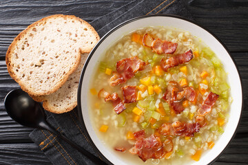 Traditional Swiss barley soup with onions, carrots, celery and meat close-up in a plate on the table. horizontal top view from above