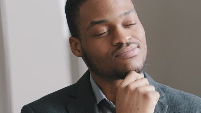 Happy dreamy satisfied young Afro American man student teacher professional look away thinks over strategy work dream about good future, smiling mixed race guy generating ideas, searching solution
