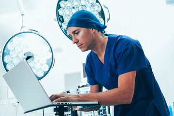 Doctor on laptop in operating theater