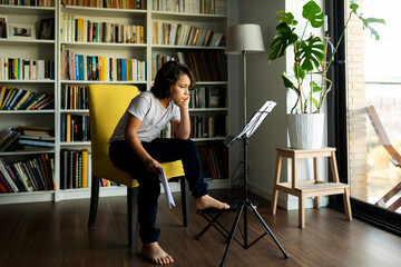 teenager boy sitting reading music scores