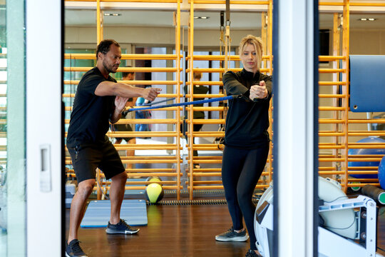 Ethnic trainer instructing sportswoman during training