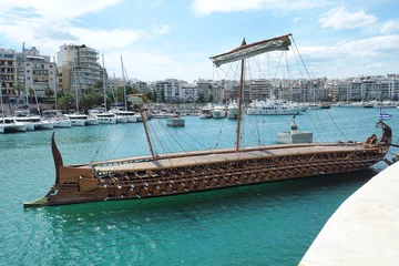Foto op Plexiglas Athenian Trireme masterpiece replica "OLYMPIAS"of ancient warship of 5th BC century, moored at port and Marina of Zea next to busy port of Piraeus, Attica, Greece © aerial-drone