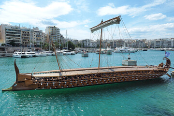 Athenian Trireme masterpiece replica "OLYMPIAS"of ancient warship of 5th BC century, moored at port and Marina of Zea next to busy port of Piraeus, Attica, Greece