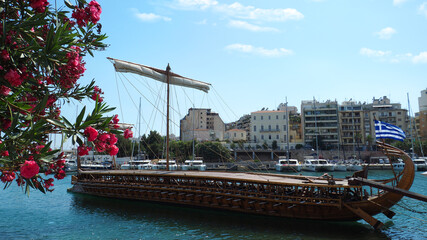 Athenian Trireme masterpiece replica "OLYMPIAS"of ancient warship of 5th BC century, moored at port and Marina of Zea next to busy port of Piraeus, Attica, Greece