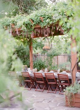 lush backyard pergola with wisteria over outdoor dining table