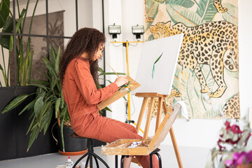 Mixed race Woman painting a picture on her home-studio.