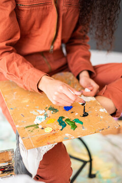 Anonymous woman with paints and painter palette