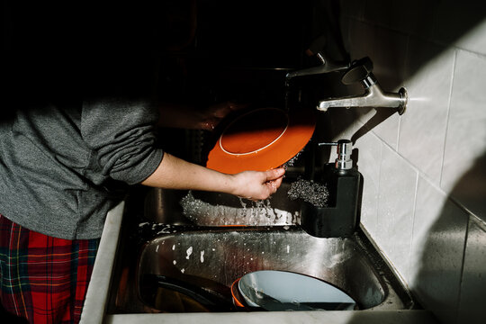 Woman washing dishes wearing pj