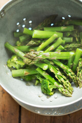 Steamed broccoli and green asparagus in colander