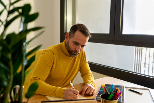 man taking notes in notepad