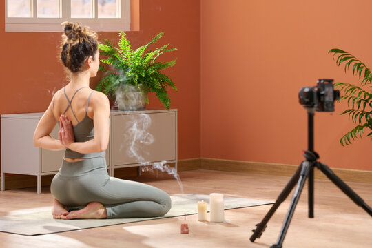 Peaceful lady during online yoga class with incense
