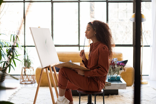 Mixed race Woman painting a picture on her home-studio.