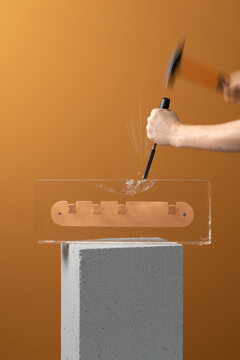 Crushing of big ice brick with frozen colorful hanger inside