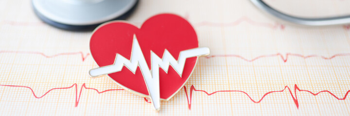 On table lies stethoscope cardiogram and heart sign