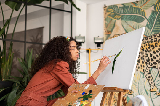 Mixed race Woman painting a picture at her studio
