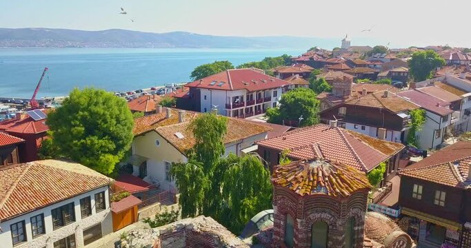 St. John the baptist church in Nesebar old town, Bulgaria. Red tiled roofs of houses and a lot of seagulls are fly