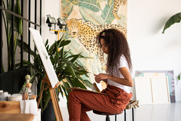Mixed race Woman painting a picture at her studio.