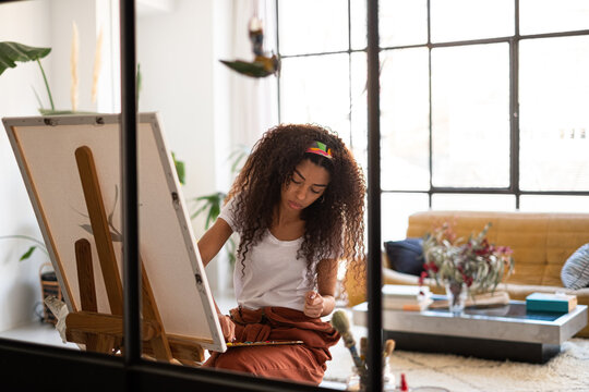 Mixed race Woman painting a picture at her studio.