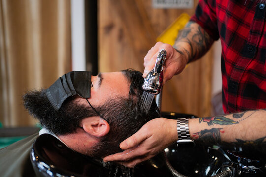 Hairdresser Washing The Head Of A Client Using A Mask.