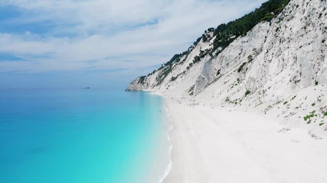 Drone raising shot of beautiful scenic beach with white sand and turquoise blue sea water. Egremni beach of Lefkada island. Egremni one of the most famous beaches in the world for their bluest waters