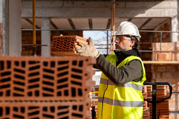 Builder transporting some bricks at construction