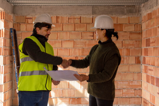 Happy architect and builder shaking hands