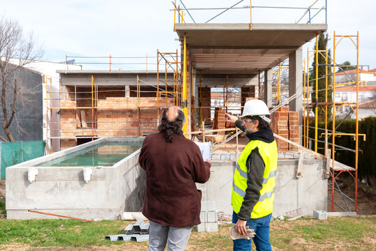 Engineer and architect discussing construction project near building