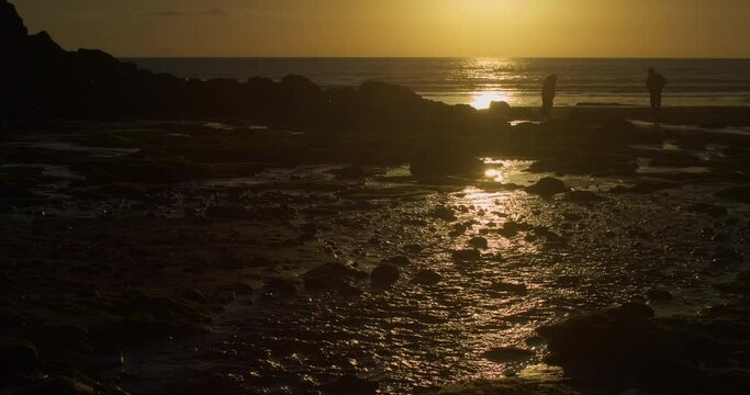 People On Chapel Porth Beach At Sunset Near St Agnes In Cornwall, England. - Static Shot
