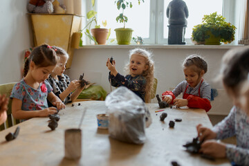 children in kindergarten have a great time and sculpt from clay 