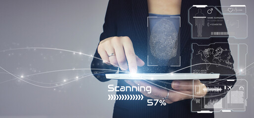 Recognition and scanning to ensure personal safety. White tablet in businesswoman hand with digital hologram fingerprint scanning sign on grey background. Futuristic and technological scanning