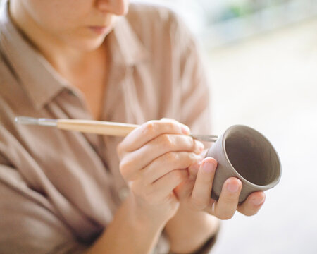 Woman make a clay cup in pottery class 