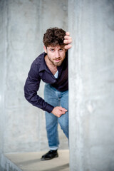 junger Mann schaut um die Ecke