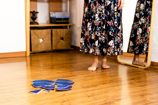 Barefoot woman smashing a plate on the floor