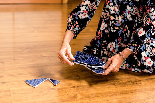 Close-up of woman picking up a broken plate 