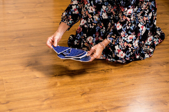 Close-up Of Woman Picking Up A Broken Plate 