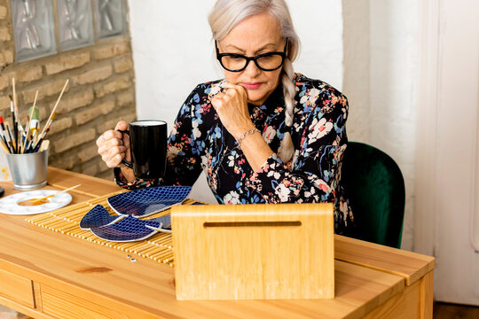 Portrait of hoary woman repairing a broken plate with a millenial japanese technique 