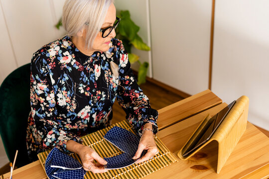 Portrait of hoary woman repairing a broken plate with a millenial japanese technique 