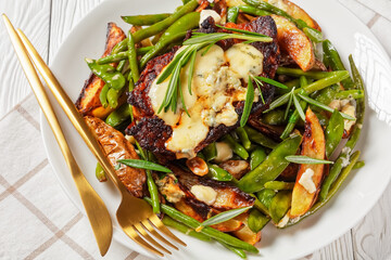 pork steaks topped with blue cheese and veggies
