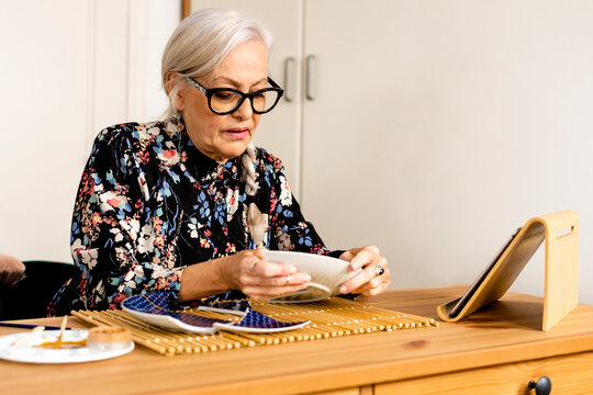 Portrait of hoary woman repairing a broken plate with a millenial japanese technique 