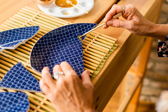 Top view of woman repairing a broken plate with gold