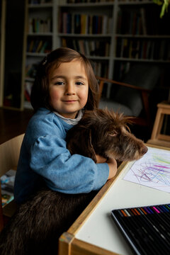 happy little girl smiling and holding her puppy