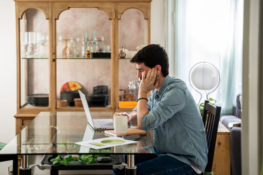 Young man working from home in living room