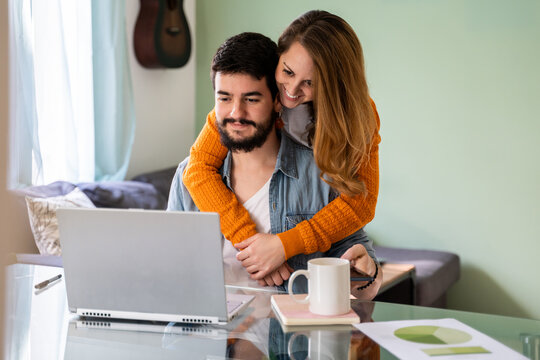 Young couple working from home in living room