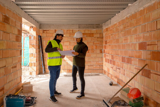 Builder and client discussing draft of new house