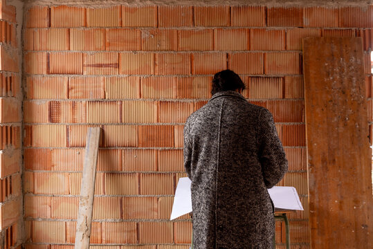 Architect woman reading blueprint of new house