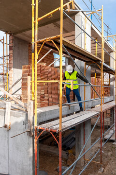 Builder walking on scaffolding on construction site