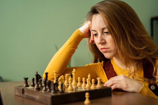 Woman playing chess at home