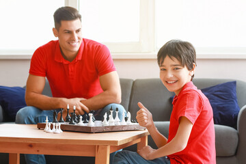 Fototapeta premium Father and son playing chess at home