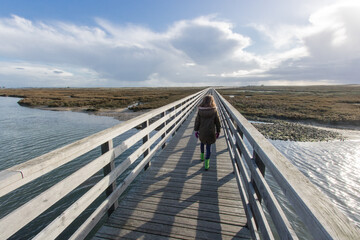 petite fille sur un ponton en bois au dessus d'un marais au bord de l'océan à la Tranche sur mer...