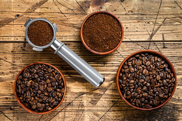 Background of coffee beans and grinded ground coffee in Portafilter. wooden background. Top view....
